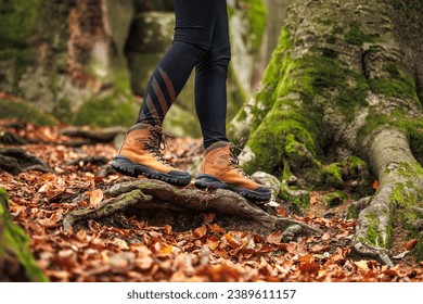 Leather hiking boot. Woman in leggings walks in the autumn woodland. Sports clothing - Powered by Shutterstock