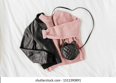 Leather Jacket And Pale Pink Warm Sweater With  Handbag On White Sheet. Women's Stylish Autumn Or Winter Outfit. Trendy Clothes Collage. Flat Lay, Top View. 