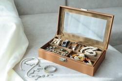 Leather Jewelry Box With Jewelry And Accessories Laid On A Couch With Sunlight Come From Window