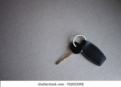 Leather Key Chain On The Fabric Sofa.