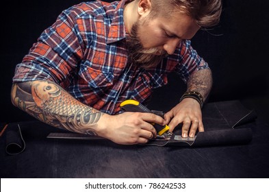 Leather maker cut leather with utility knife. - Powered by Shutterstock