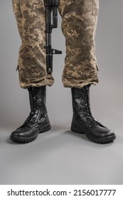 Leather Military Tactical Boots On A Ukrainian Soldier On A Gray Background