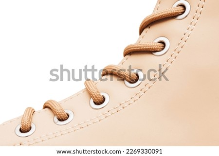 Leather shoe background. Winter shoe closeup. Brown shoelace. Thread sew pattern. Beige color footwear. Fashion background. Isolated on white. Empty copy space.