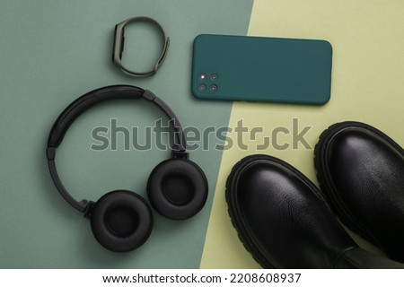 Leather shoes and modern gadgets on a green background. Top view