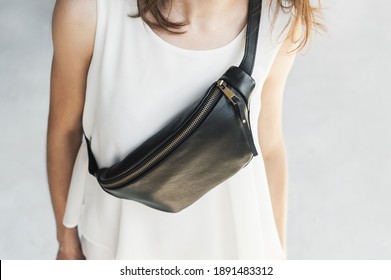 Leather Sling Bag, Fanny Pack Woman. Girl In A White T-shirt Wears A Black Banana Bag, Close-up.