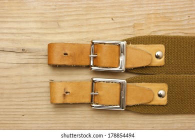 Leather Strap With A Buckle On A Wooden Board