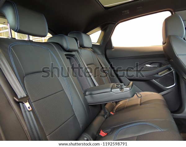 Leather trimmed folding armrest with cup holders\
in rear seats inside a vehicle\
