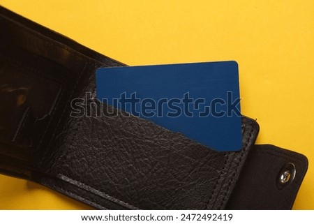 Leather wallet with credit cards on a yellow background