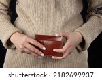 Leather wallet in female hands close-up.