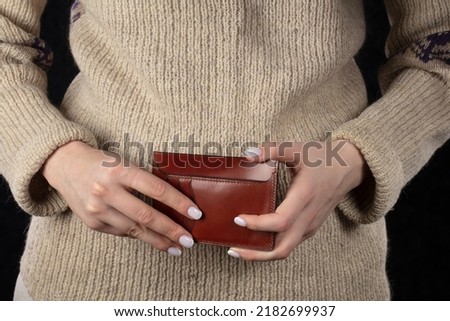 Leather wallet in female hands close-up.