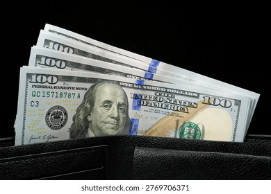 Leather wallet filled with a stack of new hundred-dollar bills. Cash, finance, savings, wealth. New hundred dollar bills in a leather wallet. New 100 dollar bills, USD