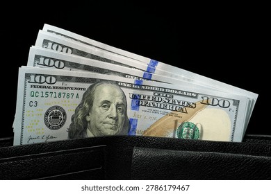 Leather wallet filled with a stack of new hundred-dollar bills