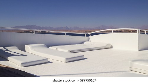 Leather white chaise lounges for rest on a yacht.