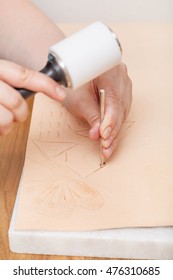 leathercraft - craftsman puts ornament on leather by stamping tool