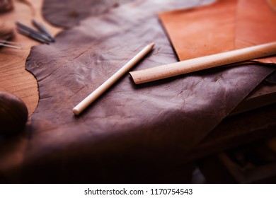 Leathersmith's work desk . Pieces of brown hide and marking pencil, tools on a work table. - Powered by Shutterstock