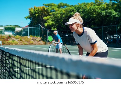 Leave it all on the court. Cropped shot of a mixed doubles tennis team playing together on a tennis court outdoors. - Powered by Shutterstock