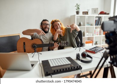 Leave Your Comment Down Below. Man And Woman Having Fun While Making Music. Couple Of Musicians Recording Video Blog Or Vlog At Home. Horizontal Shot