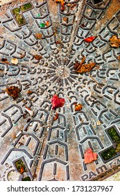 Leaves And Gravel On A Vintage Sewer Lid, Paris, France.