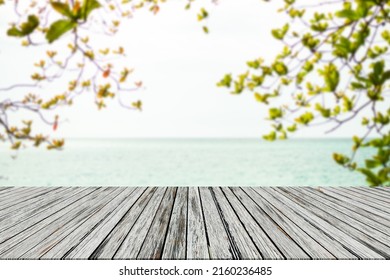 Leaves With Wooden On Sea.  Blank Table On Blue Water Shore And Blue Sky At Coast. Sunlight Blur Bokeh On Ocean. Mockup Tropical Seaside. Tourism Relax Vacation Travel Summer Holidays.