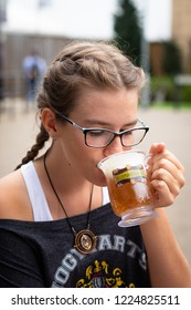 Leavesden, London, UK - July 20, 2018: Warner Bros. Studio Tour 'The  Making of Harry Potter' - teenage girl drinking famous Butterbeer from a plastic tankard in the Studio