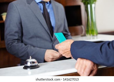 Leaving Guest Giving His Room Key Card To Hotel Receptionist