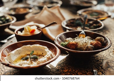 Lebanon Cuisine Served In Restaurant. A Young Company Of People Is Smoking A Hookah And Communicating In An Oriental Restaurant. Traditional Meze Lunch