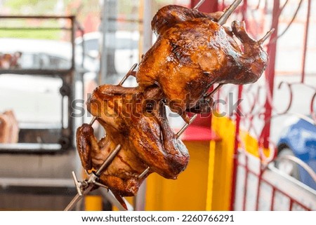 Lechon manok, a Filipino spit-roasted chicken dish. As seen being cooked in an oven at a roadside restaurant.