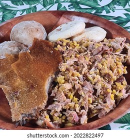 Lechona With Rice, Arepa And Potato On A White Plate And A Background With Plants.