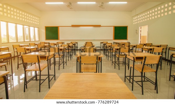 Lecture room or School empty classroom with desks\
and chair iron wood for studying lessons in high school thailand,\
interior of secondary education, with whiteboard, vintage tone\
educational concept