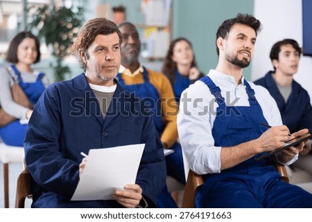 In lecture, staf employee group write on large piece of paper, fills out questionnaire, answers exam questions. Professional aptitude, identification of initiative and talented employees