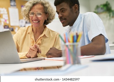 Lecturer Helps African Student At Laptop Computer In Continuing Education