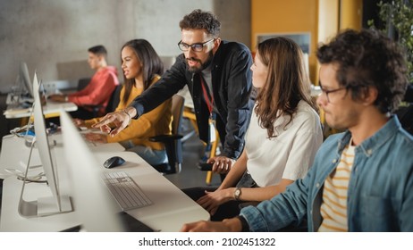 Lecturer Helps Scholar with Project, Advising on Their Work. Teacher Giving Lesson to Diverse Multiethnic Group of Female and Male Students in College Room, Teaching New Academic Skills on a Computer. - Shutterstock ID 2102451322