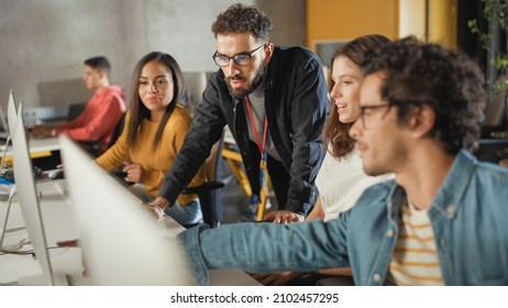 Lecturer Helps Scholar with Project, Advising on Their Work. Teacher Giving Lesson to Diverse Multiethnic Group of Female and Male Students in College Room, Teaching New Academic Skills on a Computer. - Shutterstock ID 2102457295