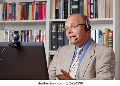 Lecturer at an online workshop with computer, camera and headset, webinar at a distance university, mooc, telelearning, e-learning