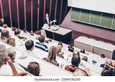 Lecturer at university. Healthcare expert giving a talk to medical faculty professors. Participants listening to lecture and making notes. - Shutterstock ID 2364196245