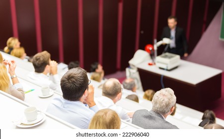 Lecturer At University. Medical Expert Giving A Talk As An Faculty Professor. Participants Listening To Lecture And Making Notes.