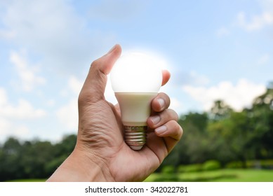 LED Bulb On Hand With Nature Background