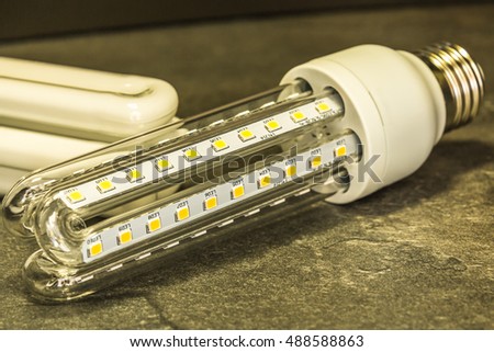 LED bulb in shape similar to a saving CFL bulbs in the foreground of the original CFL bulbs