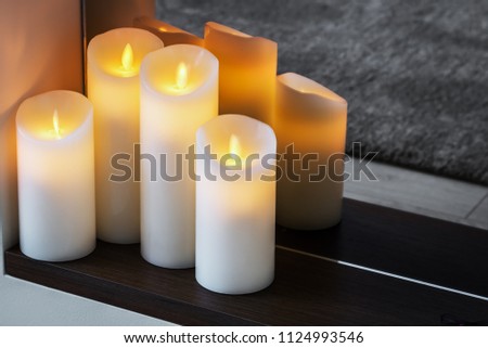 led electric candles stand in the home fireplace
