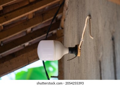 A led lamp attached to the wall of the house with a white wire. - Shutterstock ID 2054255393