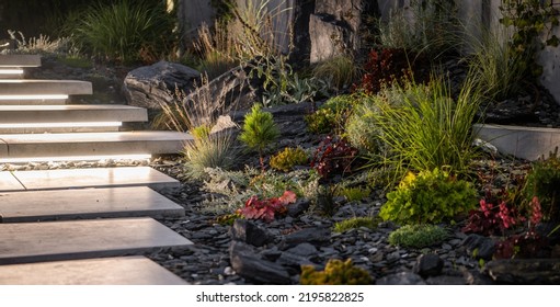LED Light Bars Illuminated Concrete Outdoor Backyard Stairs Next to Newly Developed Rockery Garden. Landscaping Industry.