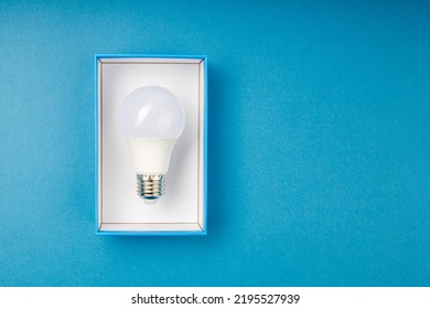 LED light bulb on a blue background in a blue box. a light bulb as a gift - Shutterstock ID 2195527939