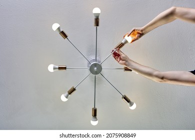 LED Light Bulbs In Ceiling Lamp, Hand Of Person Screw In Lighting Bulb.