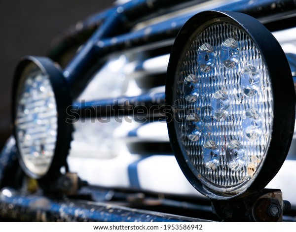Led lights on\
dirty off road car close up\
shot