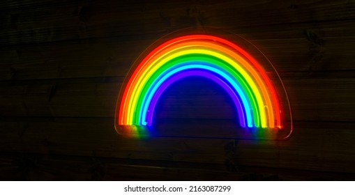 led neon rainbow hanging on the wooden wall - Shutterstock ID 2163087299