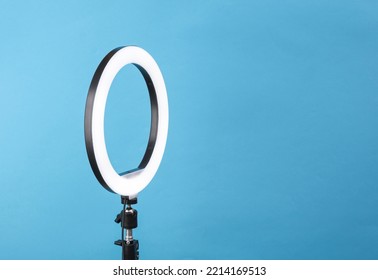 Led ring lamp on tripod, blue background