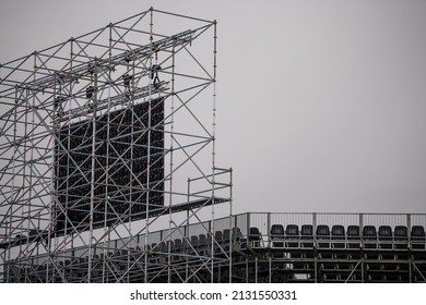 Led Screen Installed On The Stadium Before Multimedia Event. Empty Seats And Stadium Reflector Lights In Background. Shot From Behind. Scaffolding And Stadium Construction. 