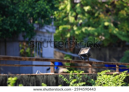 LED spotlights installed on rust iron fences to illuminate outdoor area.