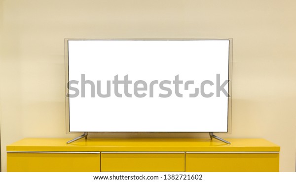 LED TV is located on
the table in the living room of the house with a white screen in
front view- Image.