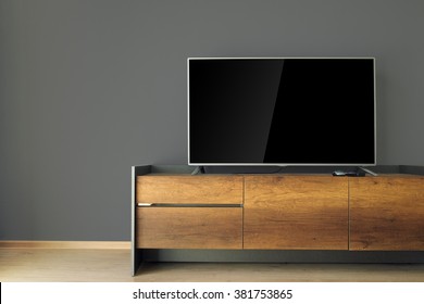 Led TV On TV Stand With Black Wall